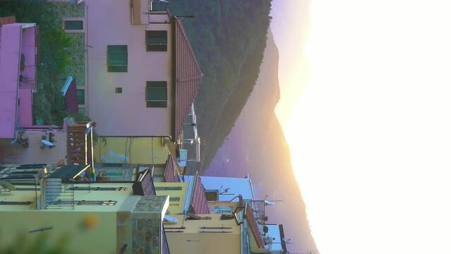 Early foggy morning in an alpine town. The rising sun illuminates the roofs of a medieval town in the mountains.. Perinaldo, Liguria, Italy.