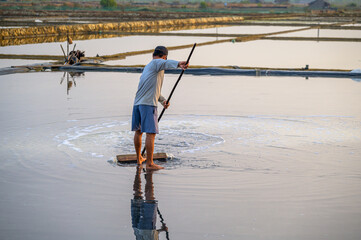 A farmer is working in the salt fields early in the morning in Can Gio district of Ho Chi Minh City, Vietnam