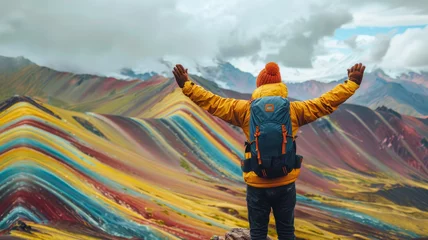 Stoff pro Meter Vinicunca a man tourist is standing with both hands raised After successfully conquering the peak , on top of a mountain,Vinicunca Rainbow Mountain,generative ai