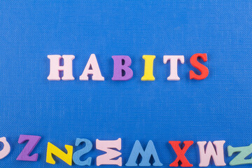HABITS word on blue background composed from colorful abc alphabet block wooden letters, copy space for ad text. Learning english concept.