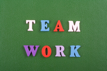 TEAM WORK word on green background composed from colorful abc alphabet block wooden letters, copy space for ad text. Learning english concept.