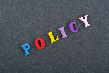 POLICY word on black board background composed from colorful abc alphabet block wooden letters,...