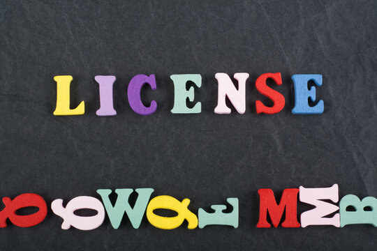 LICENSE word on black board background composed from colorful abc alphabet block wooden letters, copy space for ad text. Learning english concept.