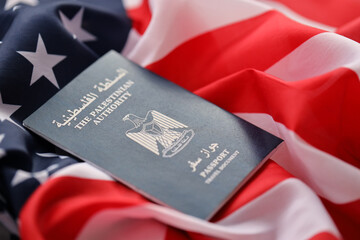Blue Palestinian Authority passport on United States national flag background close up. Tourism and diplomacy concept