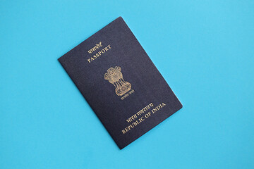 Blue Indian passport on blue background close up. Tourism and citizenship concept
