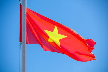 Vietnamese flag on a flagpole against the blue sky