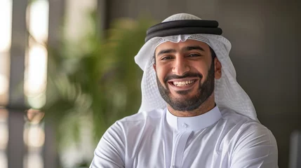 Poster Happy Emirati Arab at office wearing Kandura looking at front ideal for Middle East business concept © Sasint