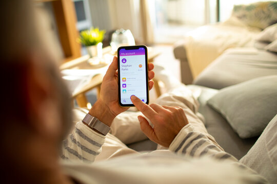 Man checking bank account on smartphone at home