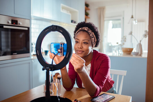 Woman creating a makeup tutorial for her vlog at home