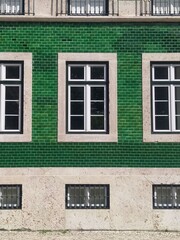 Urban Elegance: Zooming in on a Green Metro Tile Facade with Stone Window Frames - Vintage Charm in Modern Architecture