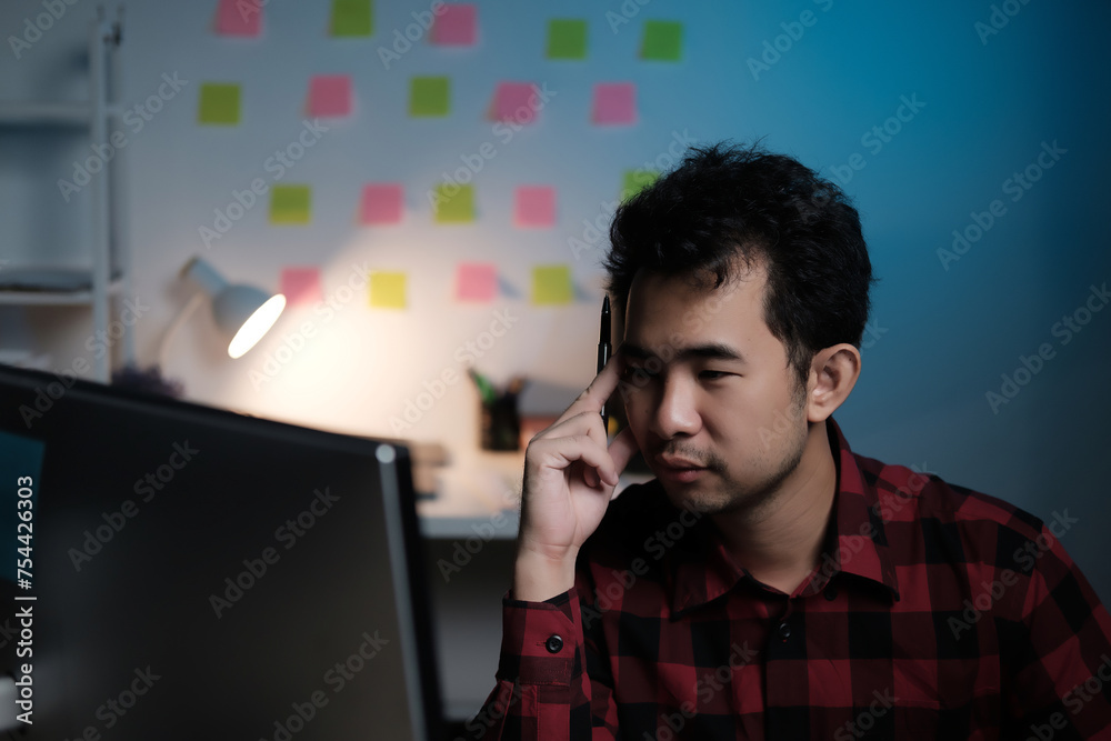Poster A man is sitting at a desk with a computer monitor in front of him