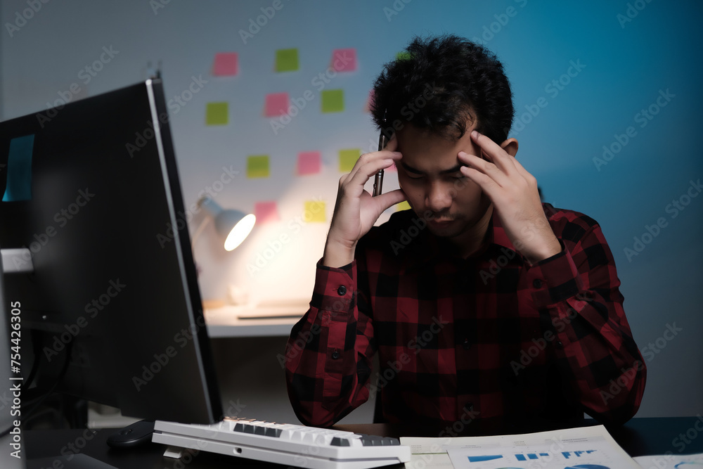 Poster A man is sitting at a desk with a computer monitor