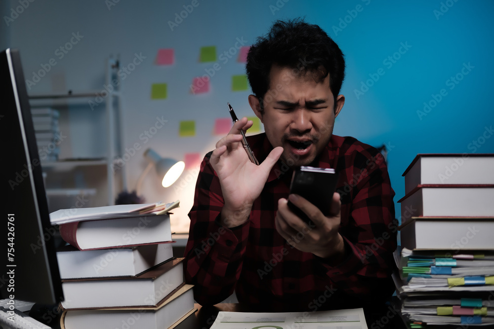 Poster a man is sitting at a desk with a stack of books and a cell phone
