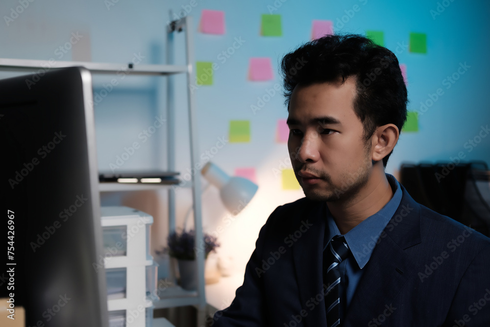 Poster A man in a suit is sitting in front of a computer monitor