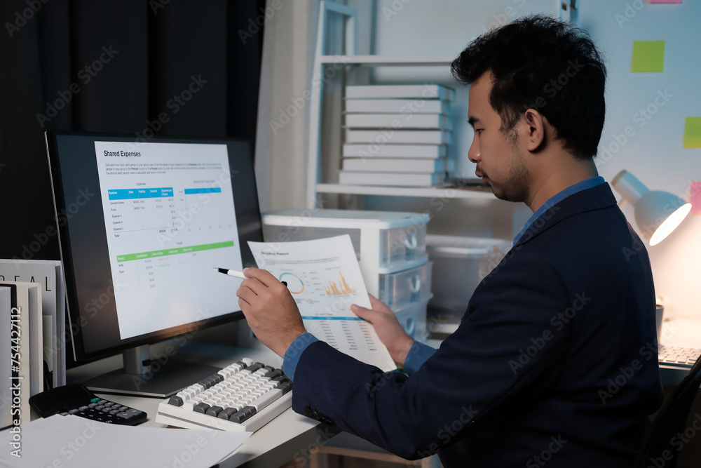 Poster A man is sitting at a desk with a computer monitor and a keyboard