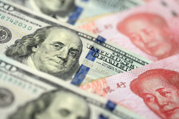 Many money bills of People Republic of China and United States. PRC Yuan and USD dollars banknotes close up