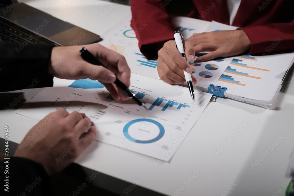 Aufkleber Two people are looking at a table with graphs and charts
