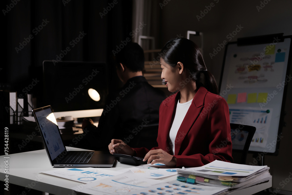 Poster a woman in a red jacket is sitting at a desk with a laptop and a calculator