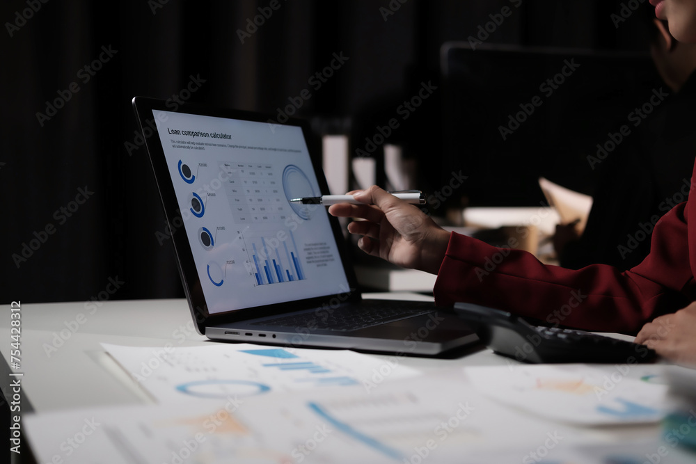 Aufkleber A person is pointing at a laptop screen with a graph on it