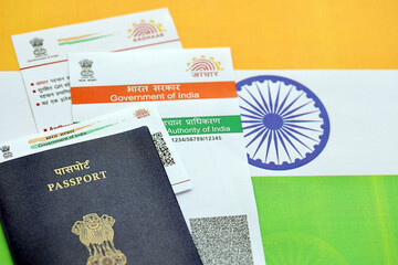 Indian Aadhaar card from Unique Identification Authority of India and Passport on Indian flag close up