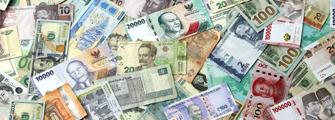 Many banknotes of different currency. Background of big amount of random money bills close up
