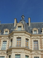 Fototapeta na wymiar Timeless Elegance: Zoomed-In View of Chateau de Sceaux with Stone Walls, Slate Roof, and Grand Windows Against Clear Blue Sky - Capturing Architectural Beauty of French Heritage