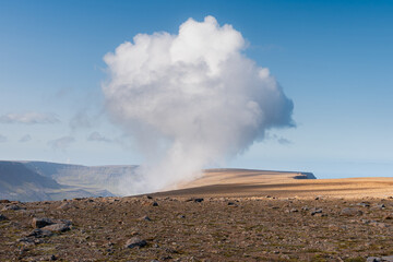 Fototapeta na wymiar Rocky landscape with huge cumulus cloud formed on top of Bolafjall mountain, Westfjords, Iceland
