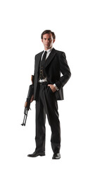 Obraz premium Handsome 1940s man with a black vest, tie and suit. Holding a gun. Handsome senior man. Full view. Font view. Isolated transparent PNG background. 