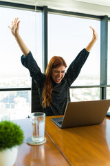 Excited Caucasian woman celebrating some great news at work