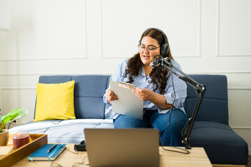 Female podcast host with a script recording an episode