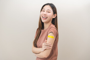 Healthcare of Covid-19, corona anti virus vaccination, happy asian young woman hand showing at bandage, plaster on her arm, getting vaccine immunity, giving injection influenza to protection pandemic.