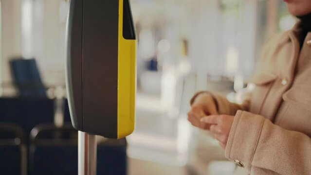 A person makes a contactless card payment at a bus fare terminal. The concept of modern, cashless transactions in public transportation.