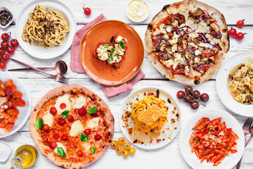 Delicious Italian food table scene. Various pizzas, pastas, gnocchi, risotto and bruschetta. Overhead view on a white wood background. - 754469171