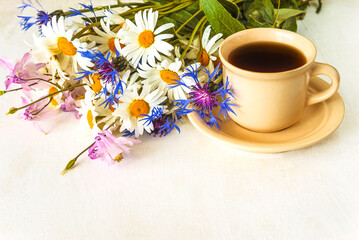 happy mother's day concept, cup of coffee and bunch of wildflowers on a white paint wooden background, copy space