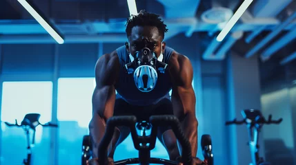 Gordijnen Man with hypoxic mask exercising on gym bike. © tiagozr