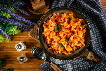 Pieces of chicken with noodle in tomato and herb sauce.