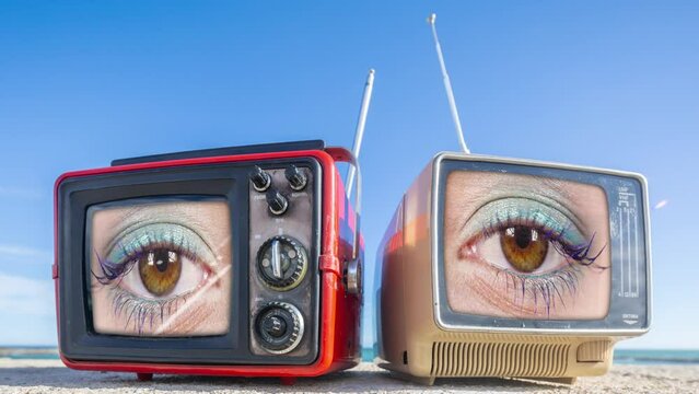 retro television and female eye on the screen on a beach