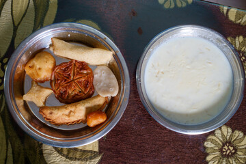 Different popular homemade food items of India and Bangladesh are isolated in a steel plate 