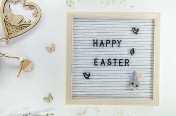 Easter composition with letter board, dried flowers, decorations on grey background, minimalistic style