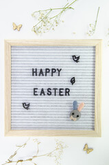 Easter composition with letter board, dried flowers, decorations on grey background, minimalistic style