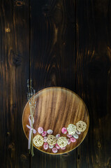 Chocolate easter eggs and dried lavender on a wooden plate with wicker balls on dark wooden background. Copy space. Easter concept.