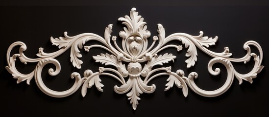 Fototapeta premium A white decorative plasterwork sample stands out against a stark black background, showcasing intricate patterns and delicate details. The contrast between the two colors enhances the elegance of the