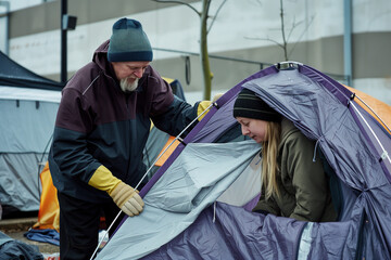 Volunteer assisting with tent setup