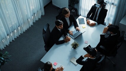 Top view of manager working on laptop and sending data analysis to business people by using VR glass headset while diverse team moving gesture while working together to planning idea. Directorate.