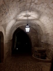 Vicolo con tunnel ad arco a Scicli, di notte, con lampione acceso.