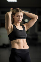 Portrait of a young beautiful blonde sportswoman in the gym.