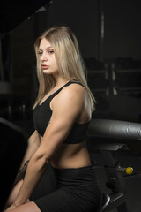 Portrait of a young beautiful blonde sportswoman in the gym.