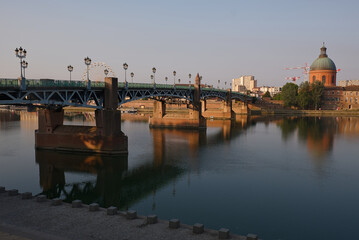 Pont Saint-Pierre Bridge in Toulouse, France. A scenic view of historic bridge.The bridge spans the Garonne River and offers a beautiful vista of the city skyline, including the iconic Ferris wheel.