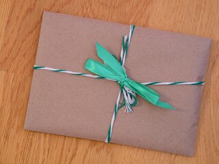A gift with a green bow on a wooden background.