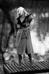 Naklejka premium Portrait of a young beautiful blonde woman outdoors. Black and white photo.